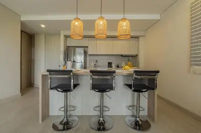 a kitchen with two bar stools and two lights at MQ903 | Jacuzzi & hamaca · Vista espectacular in Cartagena de Indias