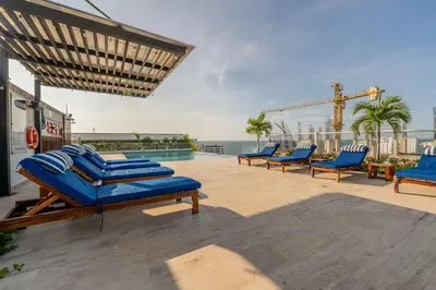 a patio with blue lounge chairs and a pool at MQ903 | Jacuzzi & hamaca · Vista espectacular in Cartagena de Indias