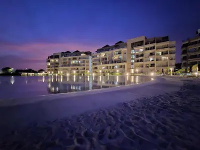 a building on the beach at night with lights at Baia Kristal - Vacaciones Cartagena Colombia in Cartagena de Indias