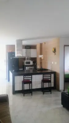 a kitchen with two bar stools and a counter top at Balcones en Bello Horizonte in Santa Marta