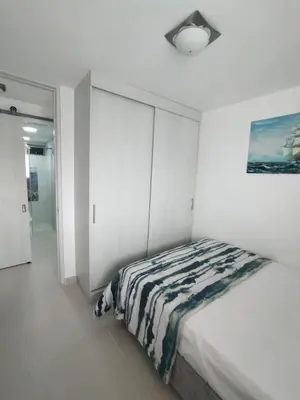 a bedroom with a bed and a painting on the wall at Sol y Brisa 811 in Cartagena de Indias