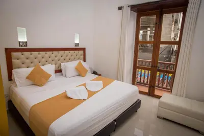 a bedroom with a large white bed and a window at Hotel Casa Tere in Cartagena de Indias