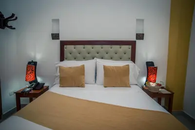 a bedroom with a large bed with two lamps at Hotel Casa Tere in Cartagena de Indias
