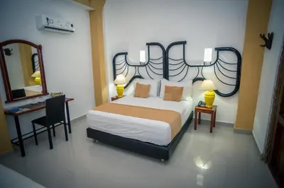 a bedroom with a bed and a desk and a mirror at Hotel Casa Tere in Cartagena de Indias