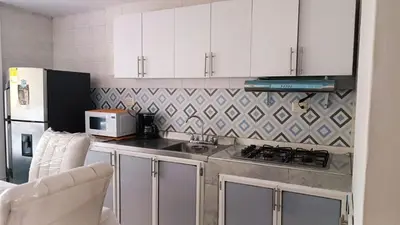 a kitchen with white cabinets and a stove and a microwave at Isabela House in Barranquilla