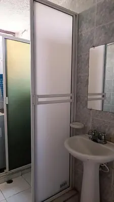 a bathroom with a glass shower door next to a sink at Isabela House in Barranquilla