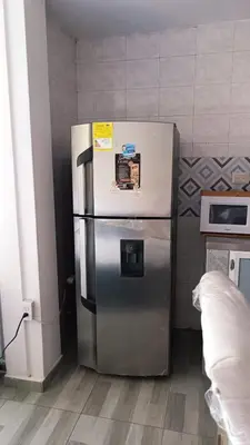 a stainless steel refrigerator in a kitchen next to a wall at Isabela House in Barranquilla