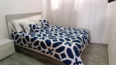 a bedroom with a bed with a blue and white comforter at Isabela House in Barranquilla