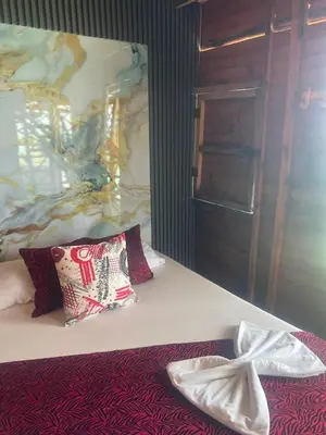 a bedroom with a bed with two pillows on it at Chiki luki in Baru