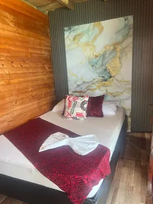 a bed in a room with a painting on the wall at Chiki luki in Baru