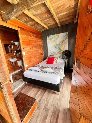 a bedroom with a bed in a wooden room at Chiki luki in Baru