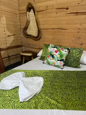 a bedroom with two beds with green sheets and pillows at Chiki luki in Baru
