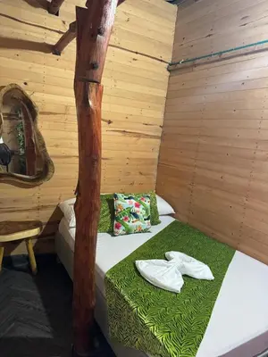 a room with a bed in a wooden cabin at Chiki luki in Baru
