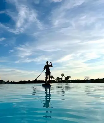 a man on a paddle board in the water at Vista a Laguna de Kristal + Bote inflable in Los Arrayanes
