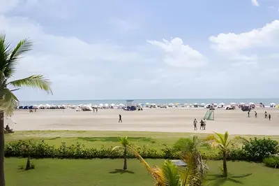 a group of people walking on a beach at 1 Dormitorio y terraza Morros. Vista mar in Cartagena de Indias