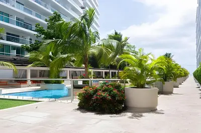 a resort courtyard with palm trees and a swimming pool at 1 Dormitorio y terraza Morros. Vista mar in Cartagena de Indias