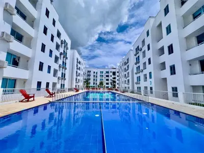 a swimming pool in the middle of two apartment buildings at Vacaciones Inolvidables in Coveñas