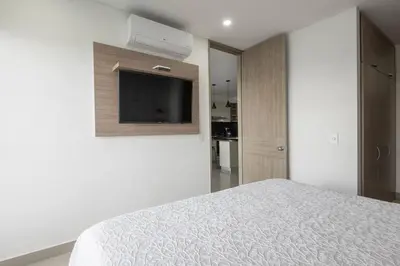 a bedroom with a bed and a flat screen tv at Apartment With Beautiful View In Infinitum in Cartagena de Indias