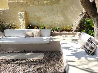 a white bench sitting on the side of a building at Apartment for 6 Guests in Sabanilla a Few Steps from the Sea in Maizal