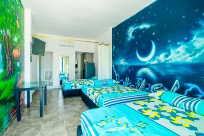 two beds in a room with a painting on the wall at Habitaciones Melany in Coveñas