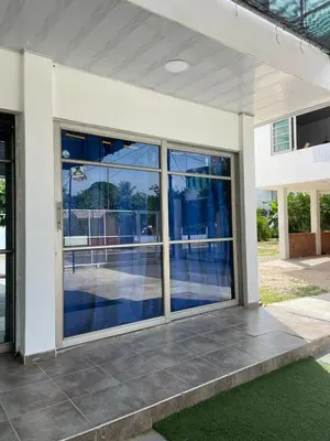 a white house with large glass doors on a patio at Habitaciones Melany in Coveñas