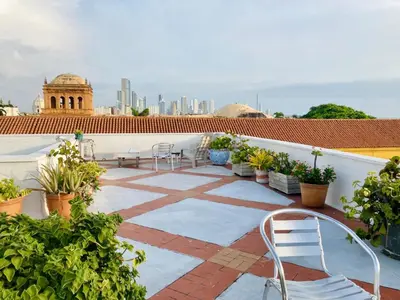 a patio with chairs and potted plants on a roof at Cartagena - stunning location in walled city in Cartagena de Indias