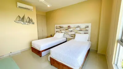 a room with two beds and a painting on the wall at Magico Apartamento Frente al Mar 3 Habitaciones AR134 in Coveñas