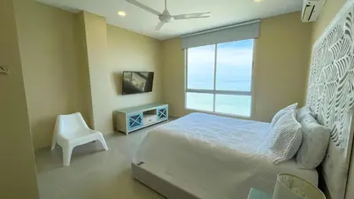a bedroom with a bed and a window and a chair at Magico Apartamento Frente al Mar 3 Habitaciones AR134 in Coveñas