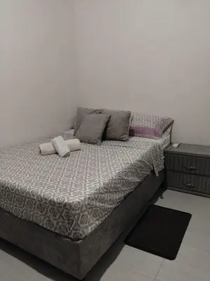 a bed in a room with a white wall at Apartamentos el farol in Ciénaga