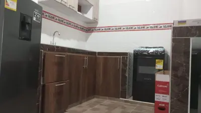 a kitchen with wooden cabinets and a sink at Apartamentos el farol in Ciénaga