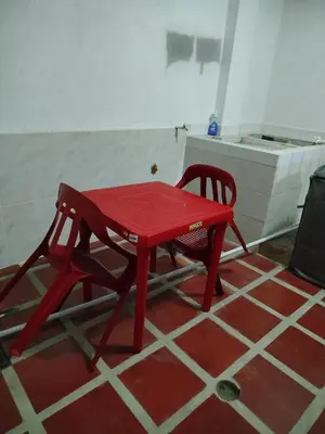 a red table and a chair in a room at Apartamentos el farol in Ciénaga