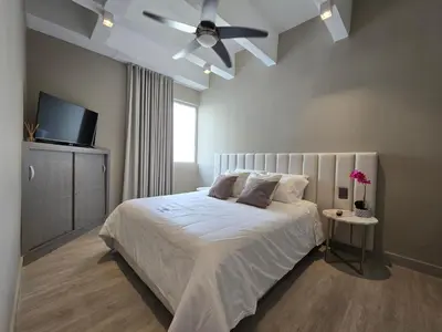 a bedroom with a bed with a ceiling fan at Moderno apartamento vista al mar y al lago piso 10 in Cartagena de Indias