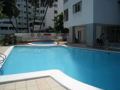 a large blue swimming pool next to a building at Moderno apartamento vista al mar y al lago piso 10 in Cartagena de Indias