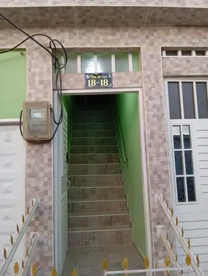 a building with a green door and stairs at Apartamentos el farol in Ciénaga
