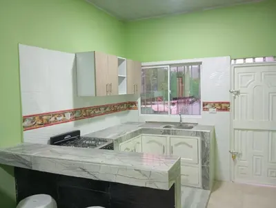 a kitchen with white cabinets and a counter top at Apartamentos el farol in Ciénaga