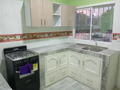 a kitchen with a stove and a sink at Apartamentos el farol in Ciénaga