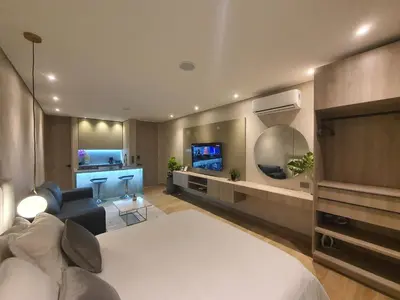 a living room with a bed and a couch and a tv at Moderna suite con balcón y vista al lago y al mar in Cartagena de Indias