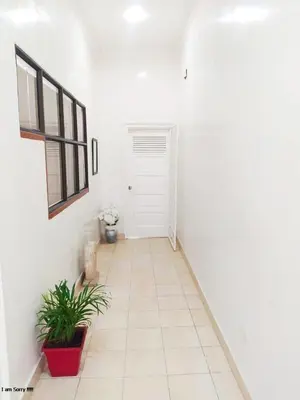 a white hallway with a door and a plant at alojamiento centro histórico - 3-2 in Cartagena de Indias
