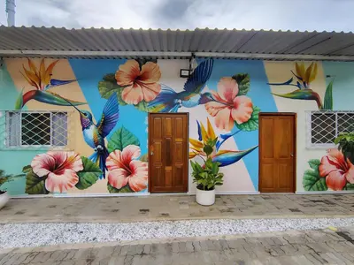 a mural on the side of a building with flowers and birds at Villa Colibrí in Santa Marta