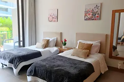 two beds sitting in a room with a window at “Lujoso Apto con Piscina, Terraza Privada y Salida a la Playa” in Cartagena de Indias