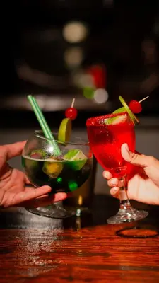two people holding cocktails on a table at Open Sea Hotel Cartagena - Frente al mar in Cartagena de Indias