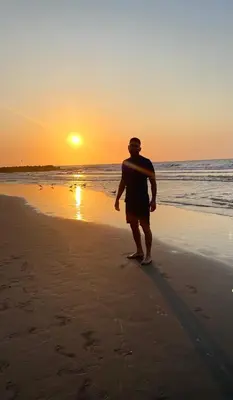 a man standing on the beach watching the sunset at Open Sea Hotel Cartagena - Frente al mar in Cartagena de Indias