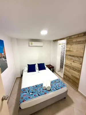 a bedroom with a large bed with blue pillows at Open Sea Hotel Cartagena - Frente al mar in Cartagena de Indias