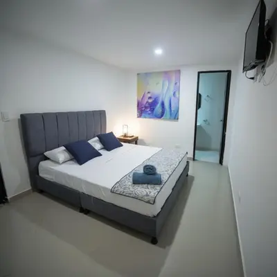a bedroom with a large bed with blue pillows at Open Sea Hotel Cartagena - Frente al mar in Cartagena de Indias