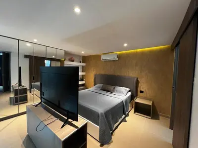a bedroom with a bed and a flat screen tv at Duplex Penthouse Rooftop Lounge in Barranquilla