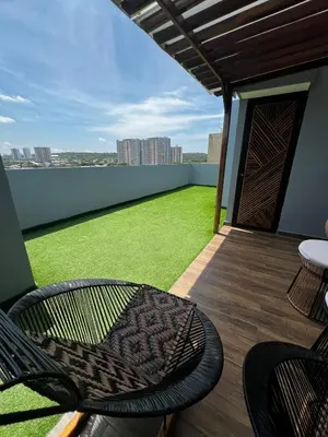 a balcony with chairs and a green field of grass at Duplex Penthouse Rooftop Lounge in Barranquilla
