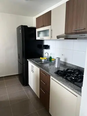 a kitchen with a sink and a black refrigerator at Duplex Penthouse Rooftop Lounge in Barranquilla