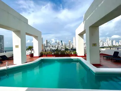 a swimming pool on the roof of a building with a city at Luxury mediterranean Suite in Cartagena de Indias