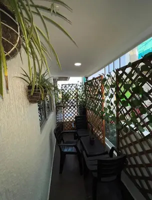 a balcony with chairs and a table and a plant at La Boquilla Oasis - Charming 1-Bedroom Apartment with Pool in Cartagena de Indias