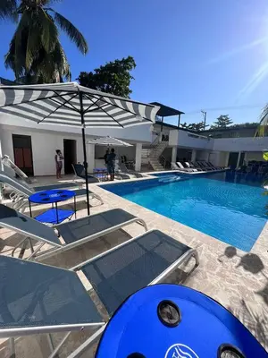 a large swimming pool with chairs and an umbrella at La Boquilla Oasis - Charming 1-Bedroom Apartment with Pool in Cartagena de Indias